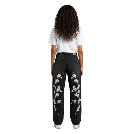 SWAGTOK black denim straight-leg jeans with embroidered white cherry blossoms on the legs. Mid-waist, zip fly.