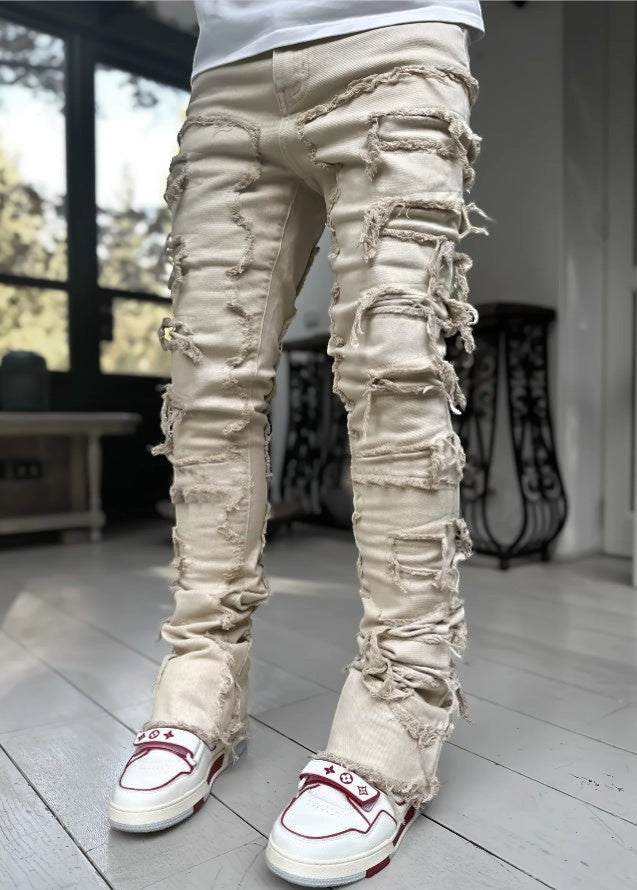 SWAGTOK men's light beige cotton stacked jeans with distressed rips and frayed edges.