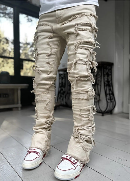 SWAGTOK men's light beige cotton stacked jeans with distressed rips and frayed edges.