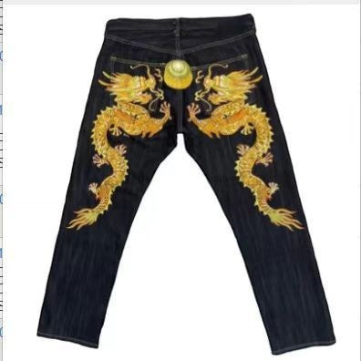 SWAGTOK black denim jeans with embroidered gold dragons on the back and a gold button detail.