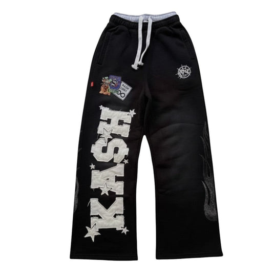 SWAGTOK black cotton blend casual straight leg trousers with 'KASH' embroidery and flame graphics.