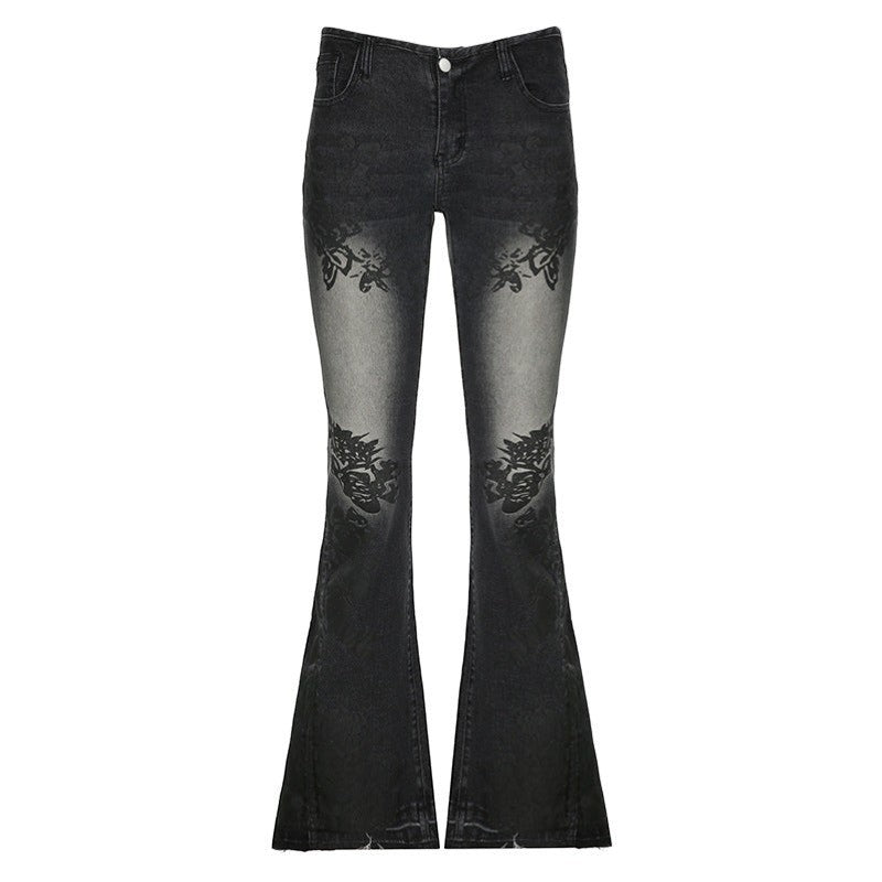 SWAGTOK black washed denim bell-bottom jeans with printed floral details on the thighs and knees.