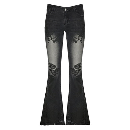 SWAGTOK black washed denim bell-bottom jeans with printed floral details on the thighs and knees.