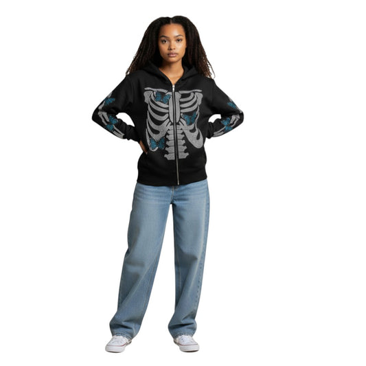 SWAGTOK black zip-up hoodie with rhinestone skeleton graphic and blue butterfly details on sleeves. Loose fit, polyester blend.
