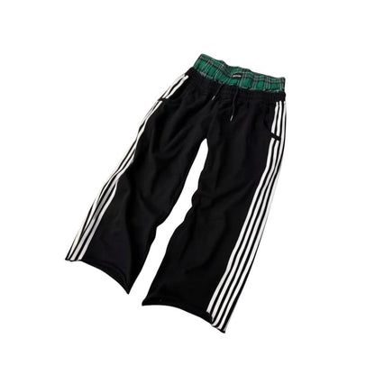 SWAGTOK black cotton blend casual sports pants with white side stripes and green plaid waistband.