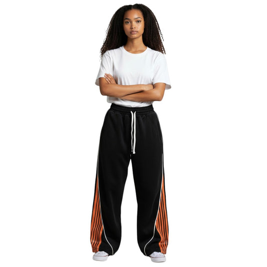 SWAGTOK black polyester loose-fit track pants with orange and white striped side panels and white drawstring.