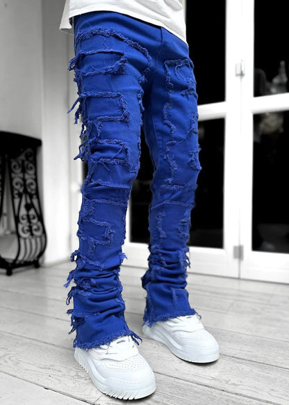SWAGTOK blue stacked jeans with distressed patches and frayed hems, made of cotton for a stylish, casual look.