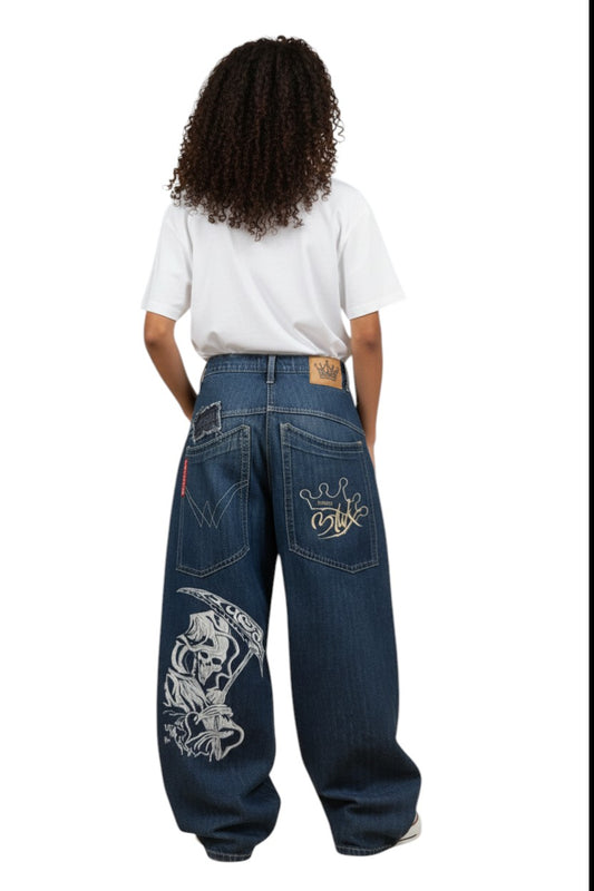 SWAGTOK blue denim loose fit jeans with skull and crown graphic prints, featuring a baggy style.