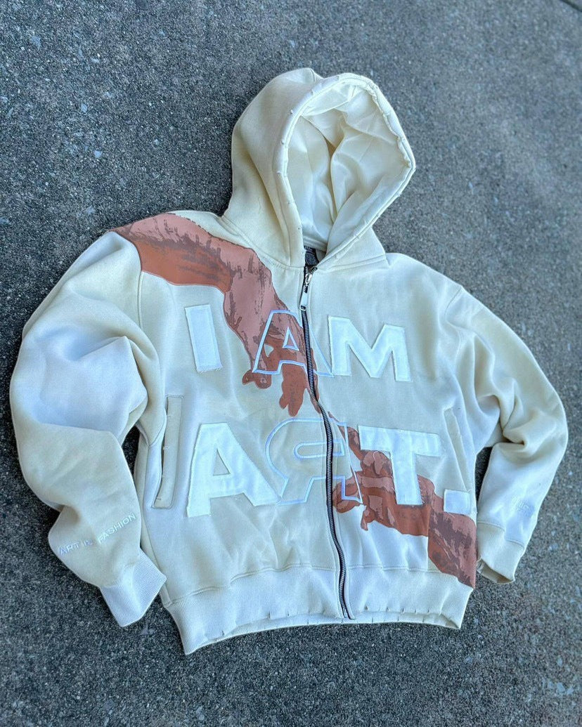 SWAGTOK cream cotton blend hooded zip-up sweatshirt with "I AM ART" graphic and hand design.