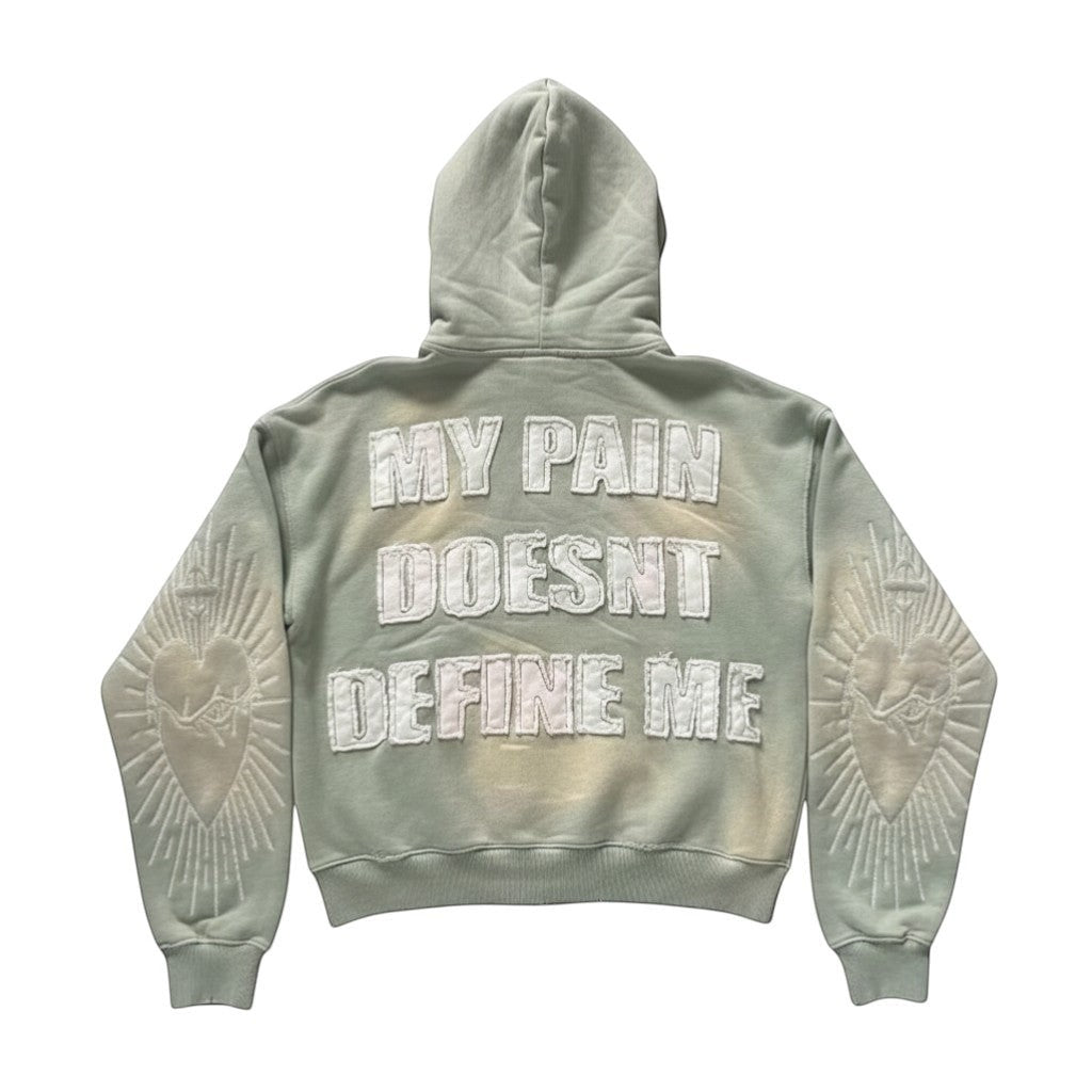 SWAGTOK light green tie-dye hoodie with embroidered "MY PAIN DOESNT DEFINE ME" text and sacred heart design on sleeves.