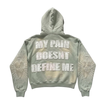 SWAGTOK light green tie-dye hoodie with embroidered "MY PAIN DOESNT DEFINE ME" text and sacred heart design on sleeves.
