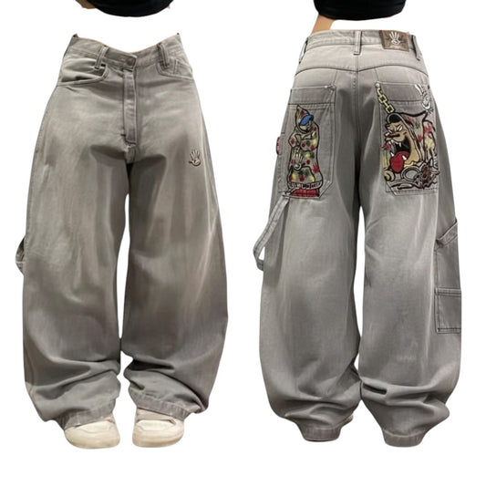 SWAGTOK grey wide leg denim pants with embroidered cartoon graphics on back pockets and a mid-waist fit.