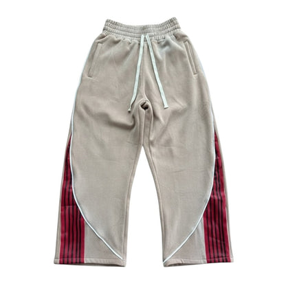 SWAGTOK khaki polyester loose fit sweatpants with red and black striped side panels and white piping.