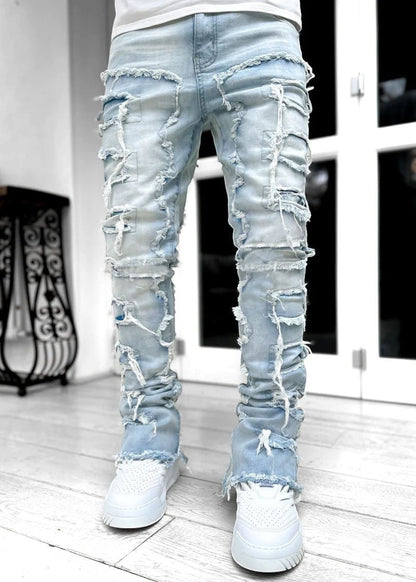 SWAGTOK light blue distressed denim jeans with patchwork and fringe details, stacked fit for men.