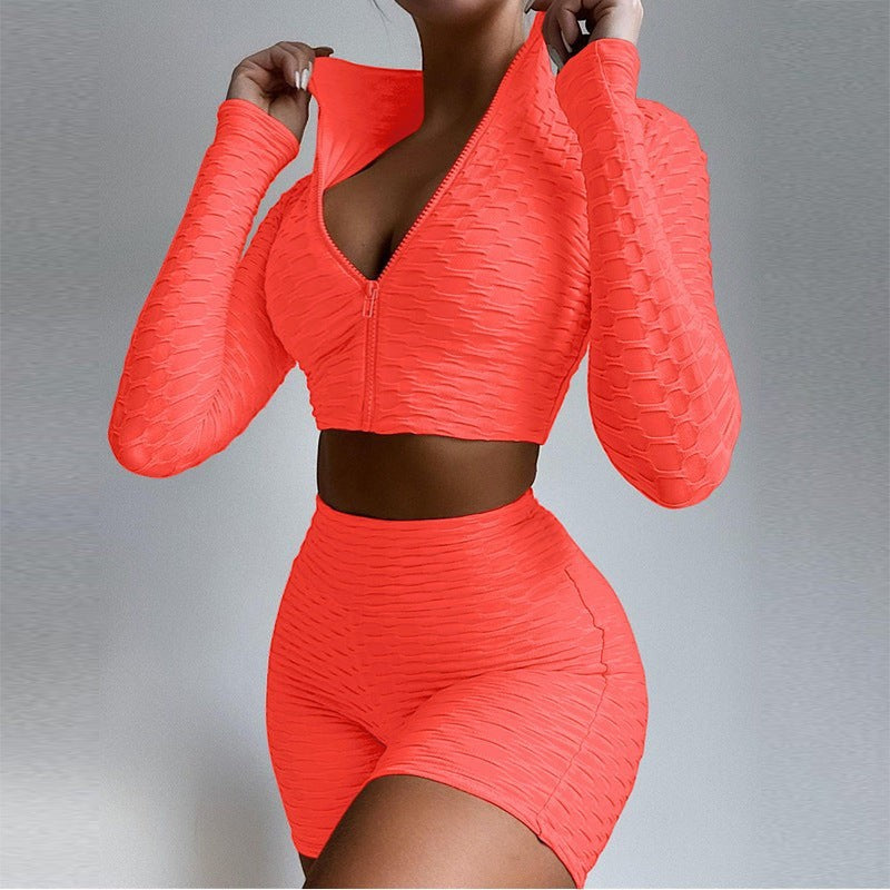 SWAGTOK women's orange textured polyester long sleeve zip-up crop top and high-waisted shorts activewear set.