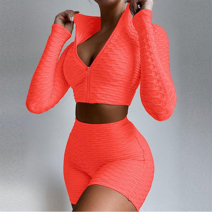 SWAGTOK women's orange textured polyester long sleeve zip-up crop top and high-waisted shorts activewear set.