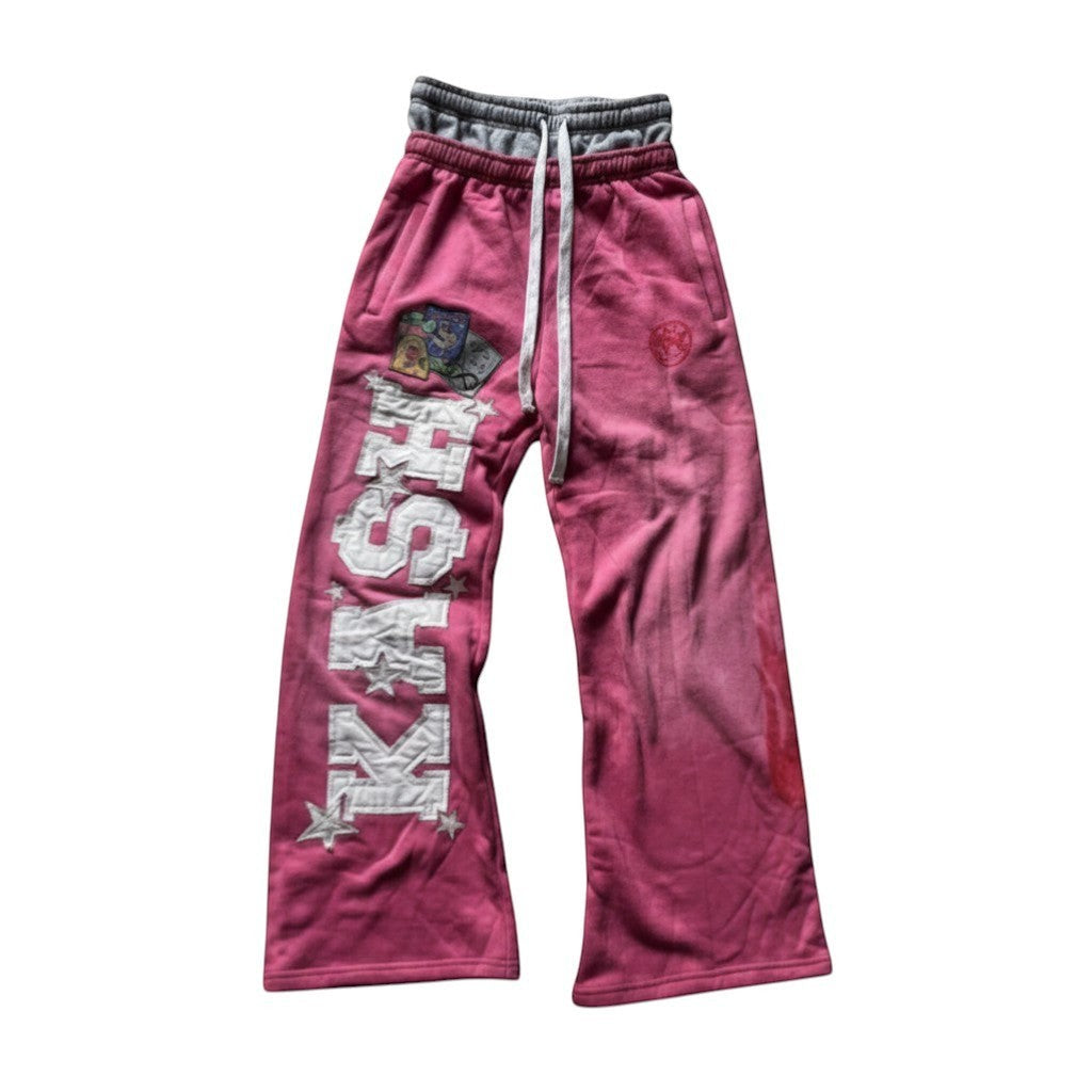 SWAGTOK pink velour wide-leg casual trousers with white 'KISH' lettering and star embroidery, drawstring waist.