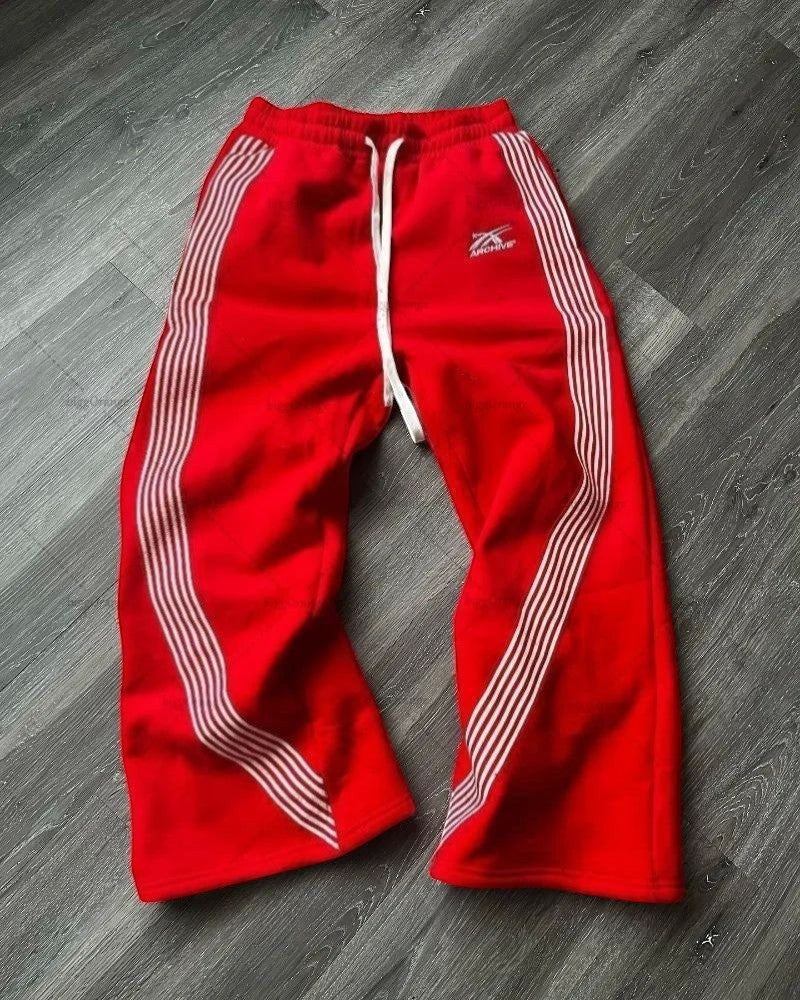 SWAGTOK red fleece sports pants with white side stripes and drawstring waist.