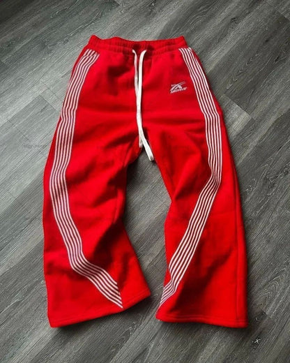SWAGTOK red fleece sports pants with white side stripes and drawstring waist.