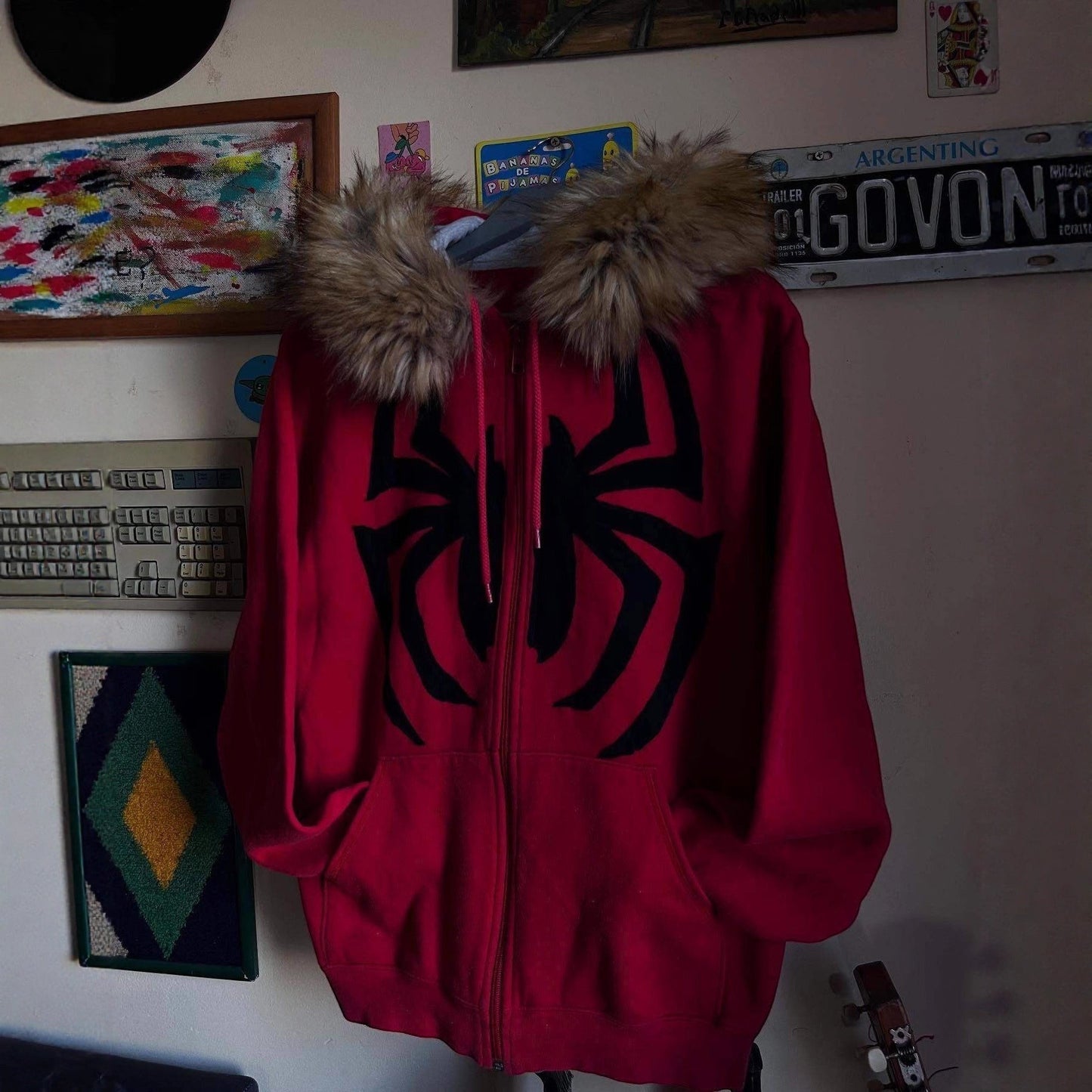 SWAGTOK red fleece hooded sweatshirt with black spider graphic and faux fur trim. Zipper front, long sleeves, street style.
