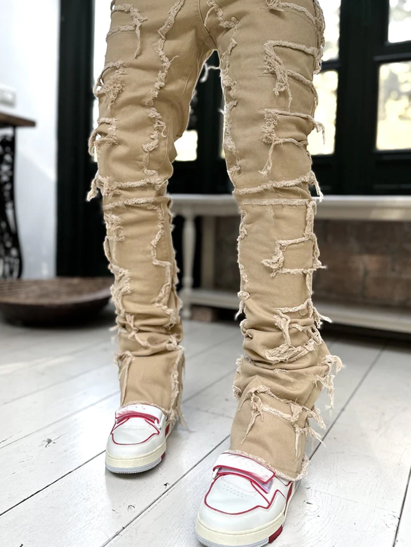 SWAGTOK men's tan cotton stacked jeans with distressed rips and frayed edges.