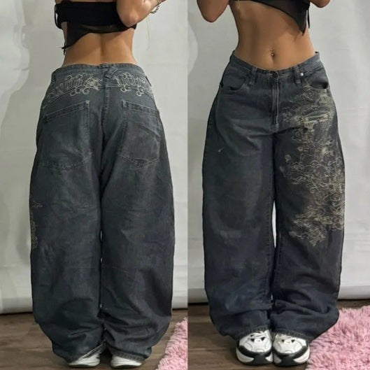 SWAGTOK dark wash denim wide-leg jeans with embroidered graphic details and high waist.